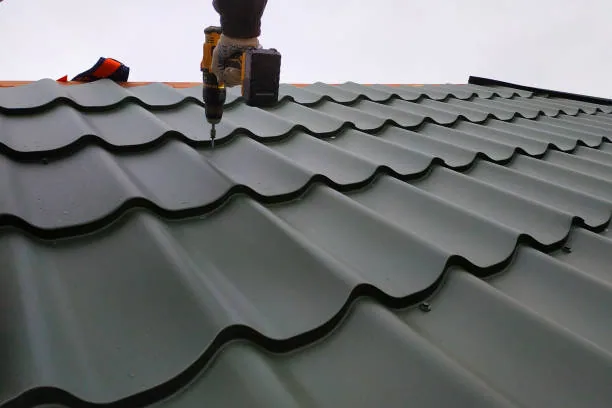 Roofer repairing a metal tile roof in Wellington